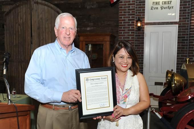 Thompson presents the award to Mayor Myrna De Vera.